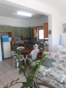 eine Küche und ein Wohnzimmer mit einem Tisch und Stühlen in der Unterkunft SEAFRONT BEACH PARTY VILLA in Perivolia