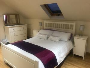 1 dormitorio con 1 cama blanca grande y TV en Tranquil Modern Countryside Bungalow, en Dungannon