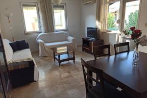 a living room with a table and a couch and a tv at Villa with pool near the sea in Konaklı