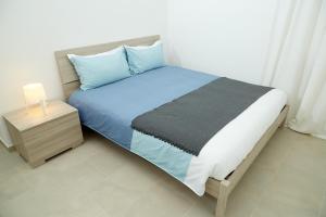 a bedroom with a bed with blue sheets and a night stand at Scirocco Guest House in Brindisi +30 photos