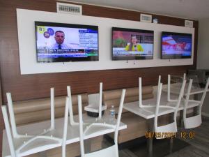 a conference room with white chairs and three televisions at Quality Inn & Suites By The Lake in Orlando