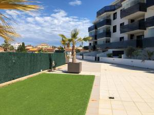 a courtyard with a palm tree in a building at City Apt - Sleeps 4 Community Pool & Parking in Denia