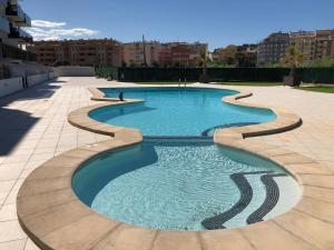 a swimming pool in a patio with a tiled floor at City Apt - Sleeps 4 Community Pool & Parking in Denia