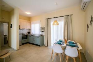 a kitchen with a table and chairs in a room at Varkes Suites 1 in Nea Potidaea