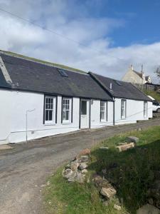 una casa blanca con techo negro en 1-2 Dialknowe Holiday Cottage - Wanlockhead en Wanlockhead