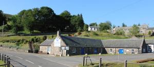 an old stone building on the side of a road at 1-2 Dialknowe Holiday Cottage - Wanlockhead in Wanlockhead