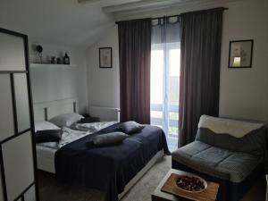 1 dormitorio con 1 cama, 1 silla y 1 ventana en Ušuškani Studio, en Zlatibor