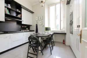 a kitchen with a table and black chairs in it at Vatican House Via Terenzio in Rome