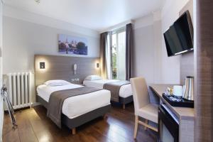 a hotel room with two beds and a desk and a television at Hôtel LUX PICPUS in Paris