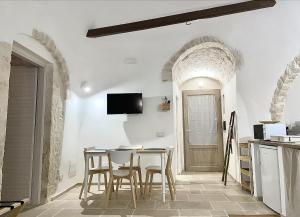a kitchen and dining room with a table and chairs at Antico Trullo Pasubio in Alberobello