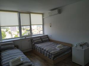 a bedroom with two beds and two windows at Top Center Nice View Studio in Gabrovo