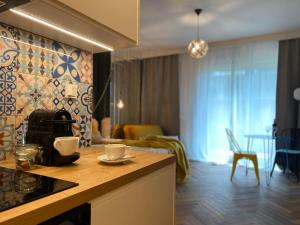 a kitchen with a counter and a living room at Uroczy apartament Art Marina z widokiem na rzekę i bezpłatnym parkingiem in Wrocław