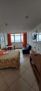 a bedroom with a bed and a couch and a table at Sol Victoria Marina Flat in Salvador