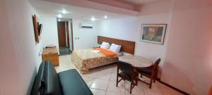 a bedroom with a bed and a table and a chair at Sol Victoria Marina Flat in Salvador