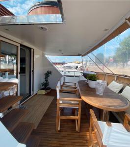 um deque de um barco com uma mesa e cadeiras de madeira em Nice VIP Cabin in a Luxurious Yacht em Estocolmo