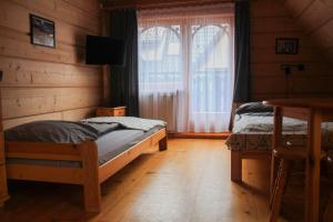 een slaapkamer met 2 bedden en een raam bij Swistowka in Zakopane