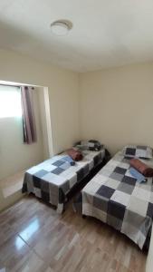 um quarto com duas camas num quarto com uma janela em Rioli quarto 2 em Caruaru