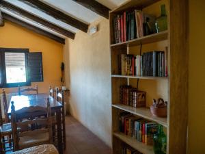 DurónCasa Rural El Botánico的用餐室配有桌子和书架,