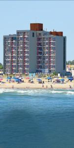 um grupo de pessoas numa praia com edifícios em The Breakers Resort Inn em Virginia Beach