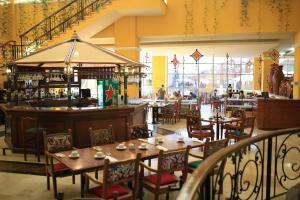 a restaurant with tables and chairs and a bar at Nk Hotel Nekié Tepic in Tepic