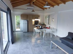 uma cozinha e sala de estar com uma mesa e um sofá em Villa Marianthi Afroditi House in Achillion woods em Achílleion