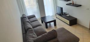 een woonkamer met een bank en een tv bij GERI'S in Durrës