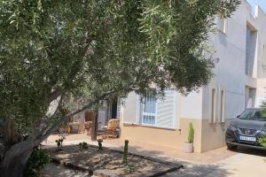 a car parked in front of a house with a tree at CASA MARITE in San José