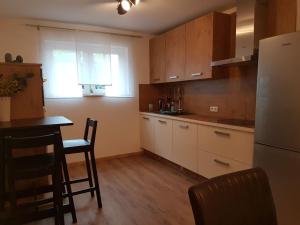 a kitchen with white cabinets and a table and a refrigerator at Jakobs Apartment in Sehnde