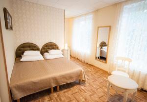 1 dormitorio con cama, mesa y espejo en Villa & Restoran Soffa, en Haapsalu