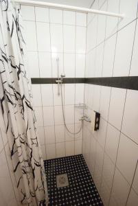 a bathroom with a shower with a black and white tiles at Villa & Restoran Soffa in Haapsalu +45 photos
