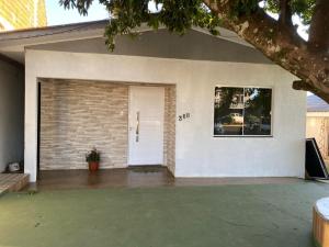 a house with a white door and a window at Casa da Árvore in Ametista do Sul