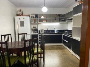 a kitchen with a table and chairs and a refrigerator at Casa da Árvore in Ametista do Sul