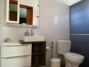 a bathroom with a white toilet and a sink at Casa da Árvore in Ametista do Sul