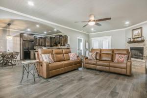 a living room with two leather couches and a kitchen at Cheerful 3 Bedroom Home, King Bed, 10 min from Palo Duro Canyon, Fireplace, Washer Dryer in Canyon