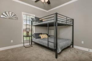 a bedroom with a bunk bed and a ceiling fan at Cheerful 3 Bedroom Home, King Bed, 10 min from Palo Duro Canyon, Fireplace, Washer Dryer in Canyon