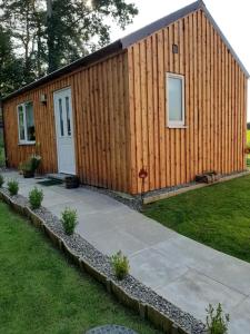 un pequeño edificio de madera con puerta y acera en Beautiful studio chalet in the Highland, en Inverness