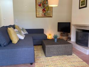 un salon avec un canapé bleu et une télévision dans l'établissement Aroeira - Sea & Golf Apartment, à Aroeira