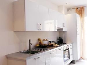 a kitchen with white cabinets and a sink at Antik Malta in Sliema