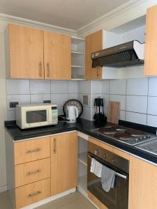 a kitchen with a microwave oven and a stove at Magnolia apart Con facturas in Iquique