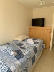 a bedroom with a bed and a flat screen tv at Magnolia apart Con facturas in Iquique