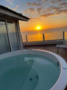 bañera en el balcón con puesta de sol en Terrazas Al Mar en Pinamar