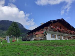 a house with flowers on the side of it in a field at Klettnerlehen in Ramsau