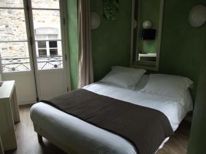 a bed in a green room with a window at Le Minotel in Vitré