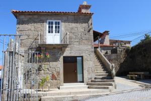 a small stone building with a door and stairs at Alojamento Local Boega Hotel - Casas Boega I e II in Gondarém