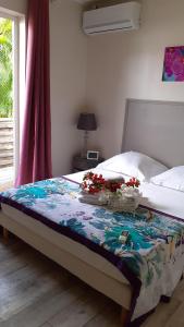 - un lit fleuri dans une chambre dans l'établissement Cosy By Mélanie - Un hôtel comme chez vous, à Fort-de-France