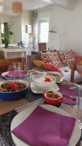 a table with plates and bowls of food on it at Cosy By Mélanie - Un hôtel comme chez vous in Fort-de-France
