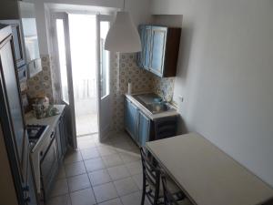 una pequeña cocina con armarios azules y fregadero en B & B da Maria en Ancona