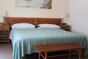 a bedroom with a bed with a green blanket and two pillows at Villa Corallo in Grado