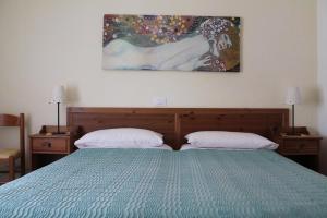 a bedroom with a green bed with two pillows at Villa Corallo in Grado