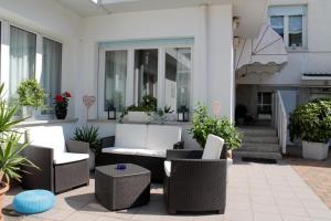 a patio with wicker chairs and tables at Villa Corallo in Grado